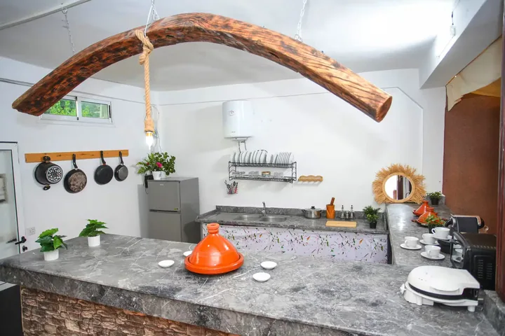 La cuisine : plan de travail, tajine et casseroles suspendues.