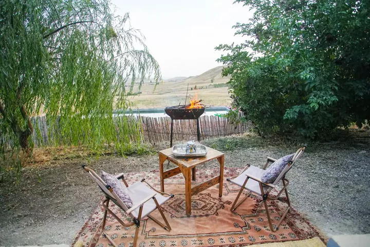 Le feu allumé au crépuscule, entre les fauteuils et le tapis berbère, face aux collines.